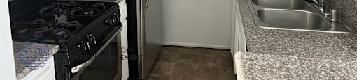 A kitchen with black appliances and white cabinets.